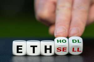 A person is holding dice embedded with the words eth, DHL, and sell, exemplifying the integration of blockchain technology in the crypto space.