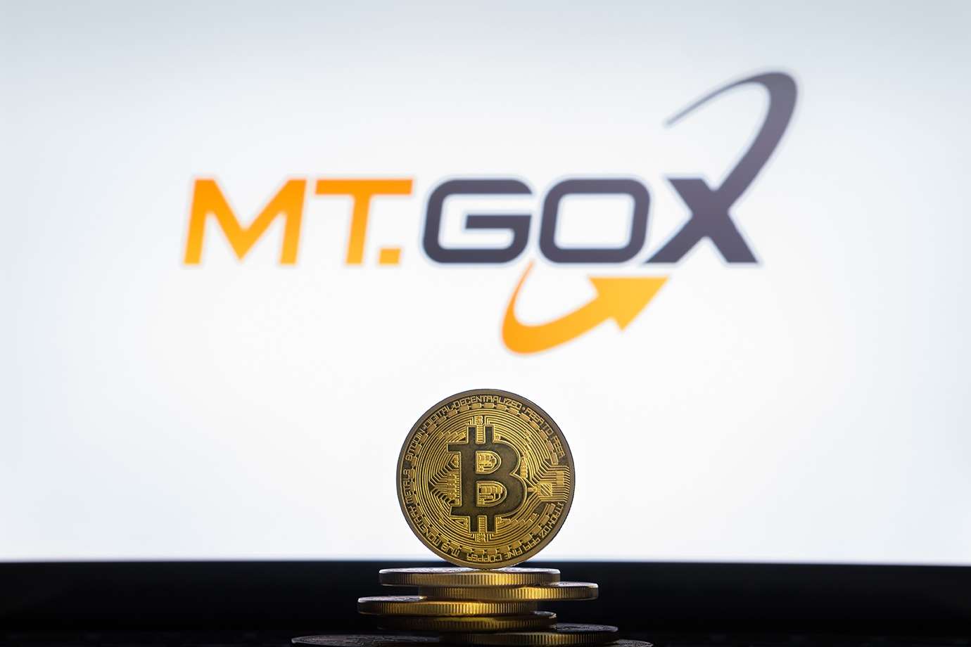 A stack of bitcoins in front of the mt Gox logo showcasing the power of ukcrypto.
