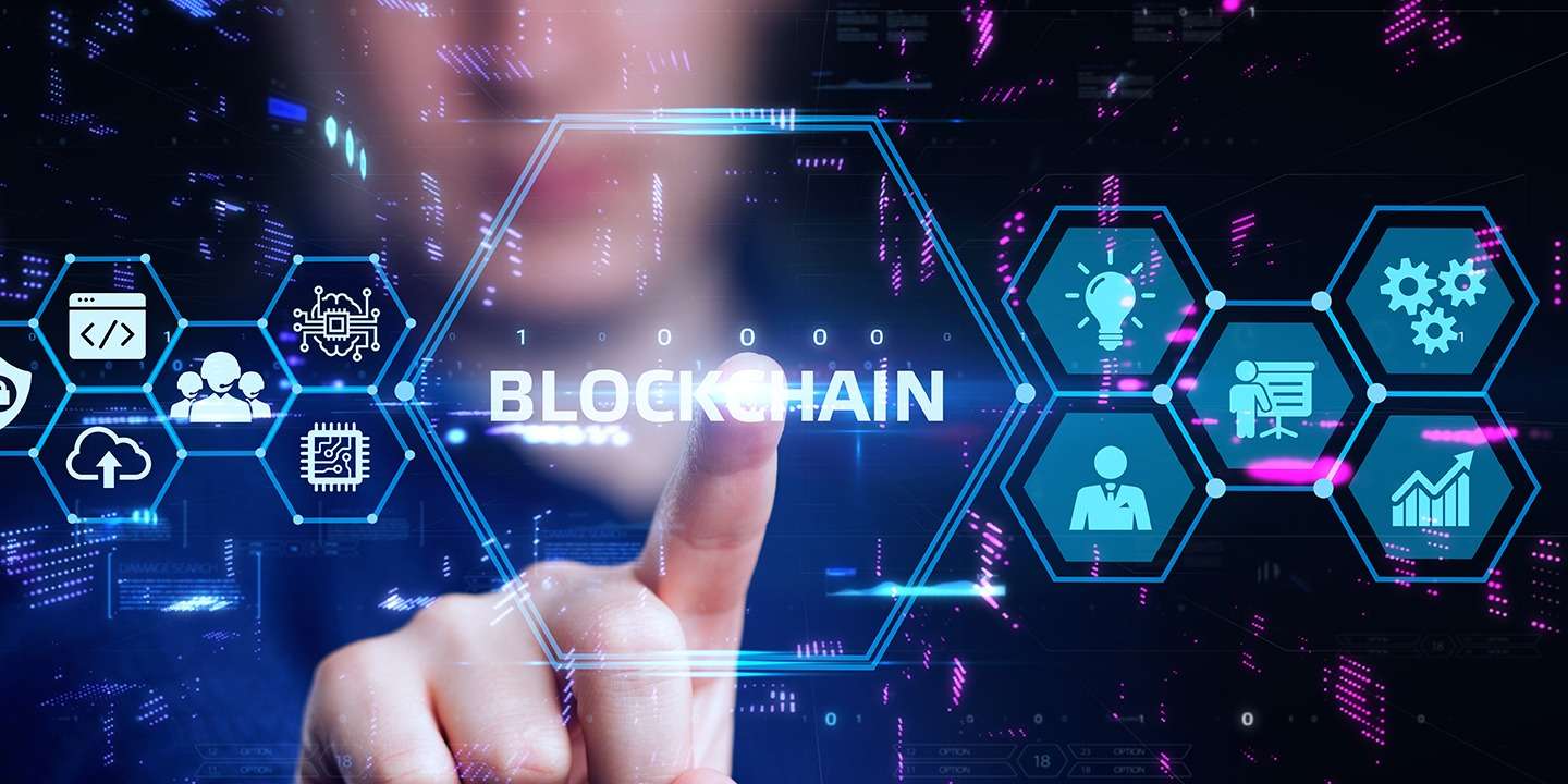 A woman is pointing to the word blockchain on a screen showcasing crypto technology.