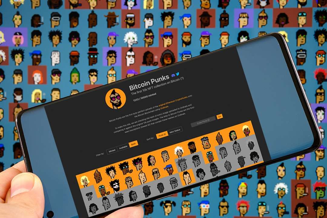 A person holding up a phone displaying multiple Bitcoin punk NFTs.