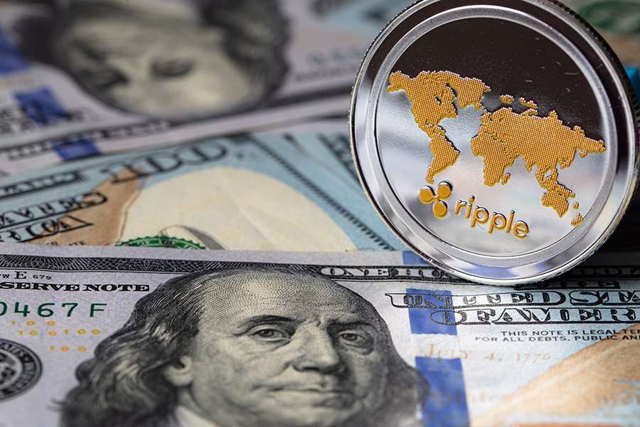 A gold coin on top of a stack of dollars, showcasing the intersection between traditional currency and cryptocurrency.