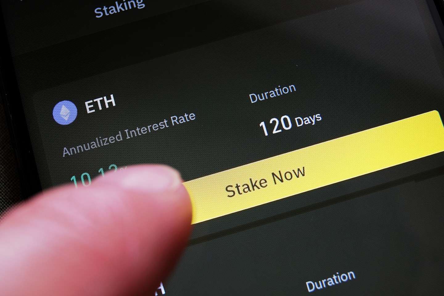 A person is pointing at the crypto button on a smartphone.