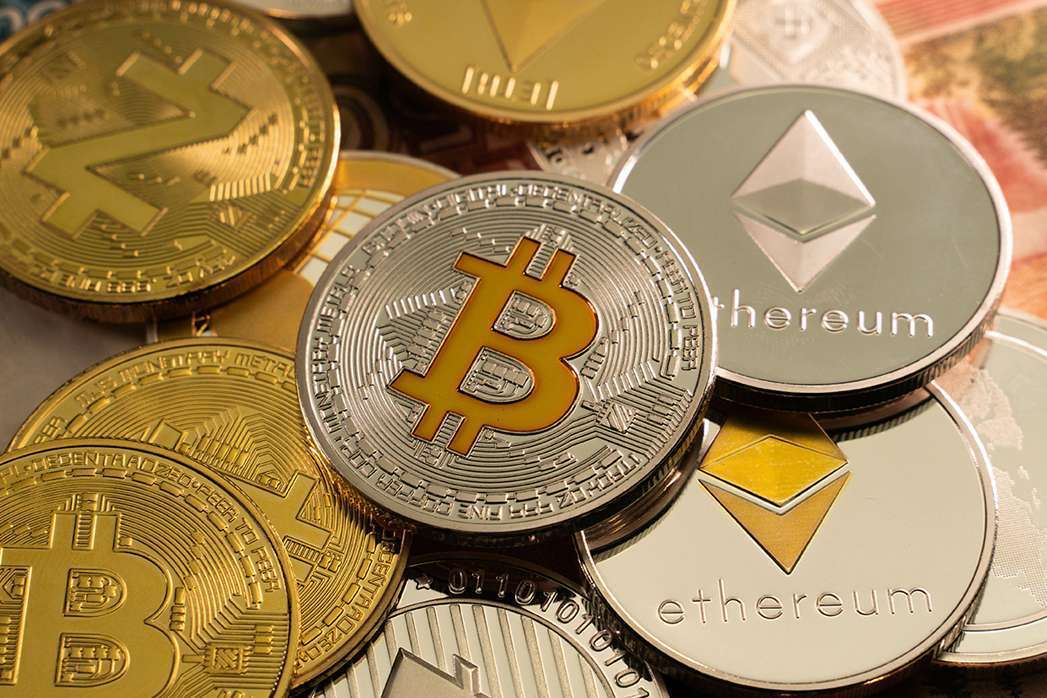 A pile of crypto coins, altcoins and bitcoin on top of a pile of money in the world of DeFi and ukcrypto.