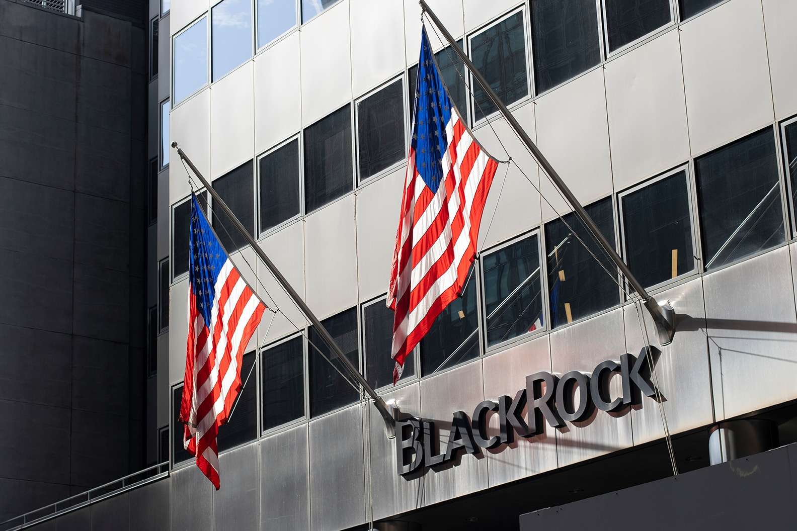 A Blackrock building adorned with two american flags, symbolizing national pride and resilience.