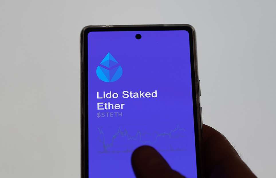 A person is holding up a phone with the decentralized finance (DeFi) app on it.