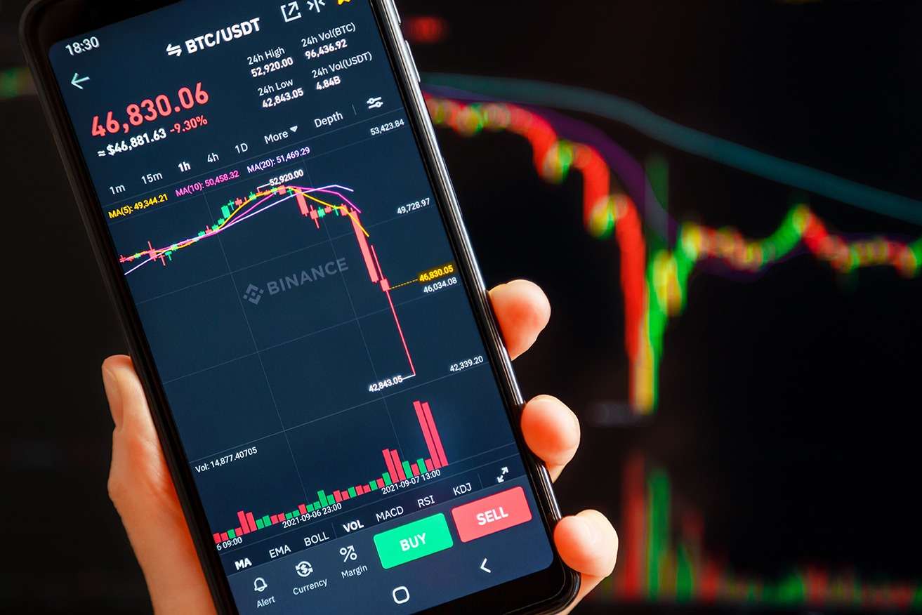 BTC/USDT chart on the Binance app on a mobile showing a liquidation of Bitcoin red candle.