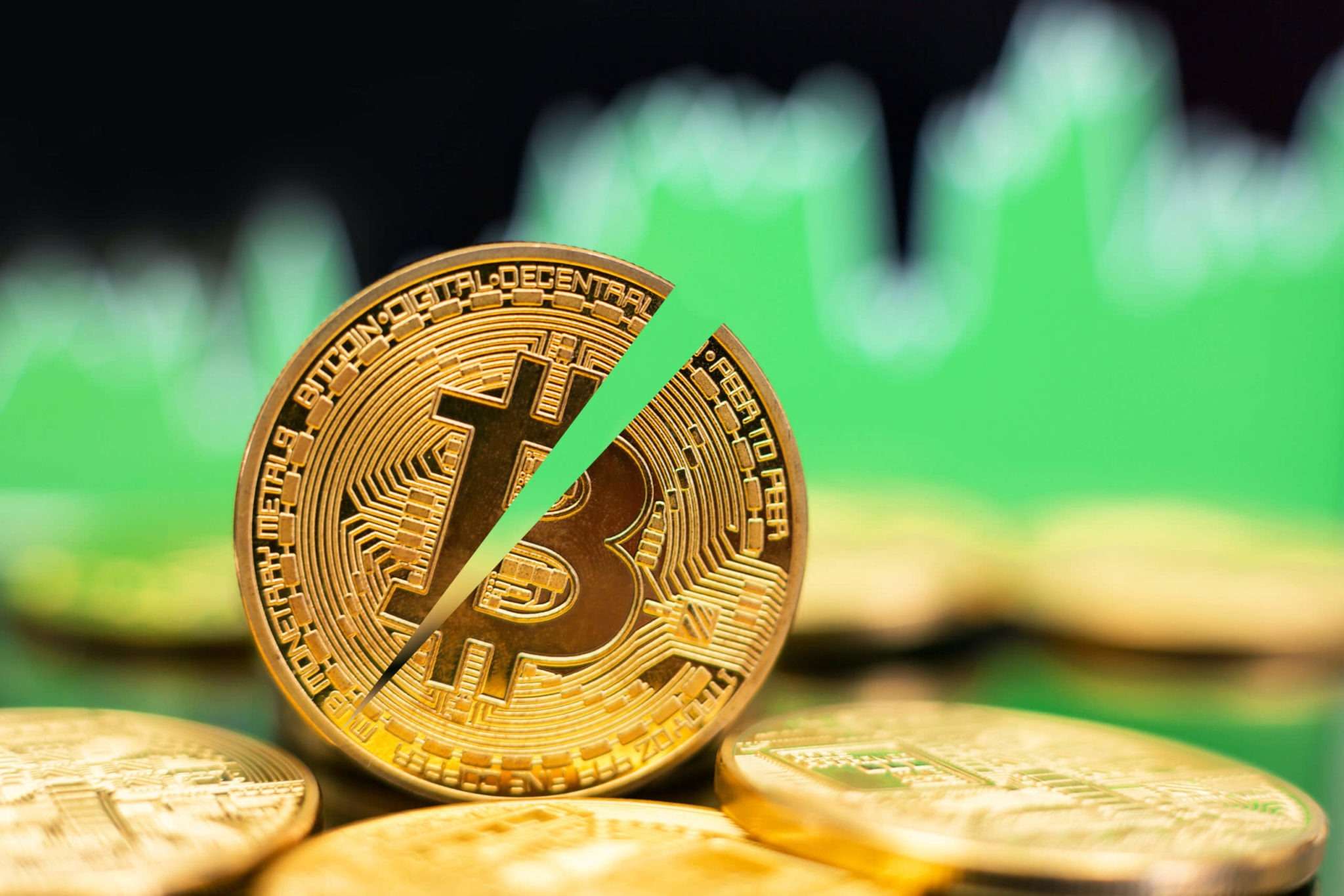 Upcoming Bitcoin Halving - half a bitcoin image on trading background.
