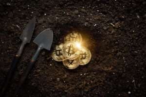 Bitcoins being mined as gold on a coal background with shovels.