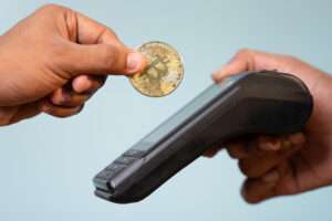 Concept showing of cryptocurrency payment - Hands paying buy placing on swiping payment machine.