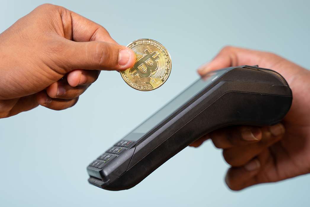 Concept showing of cryptocurrency payment - Hands paying buy placing on swiping payment machine.