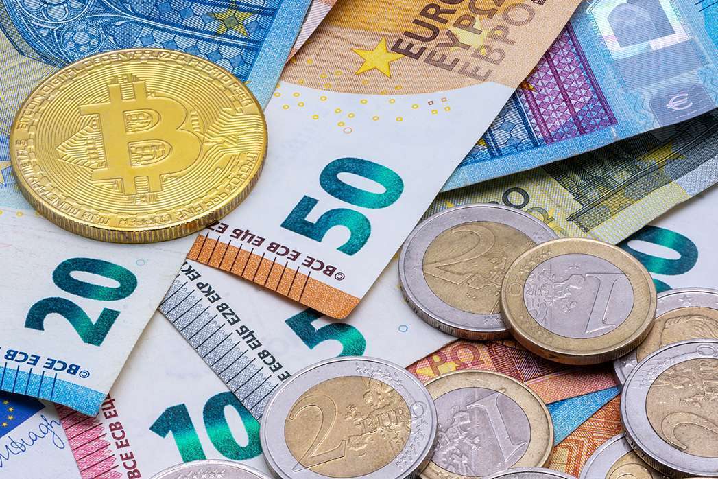 Bitcoin and Euro banknotes and coins.