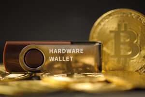 close-up of hardware wallet or digital wallet on bitcoin gold coins in cryptocurrency trading and mining investment concept.