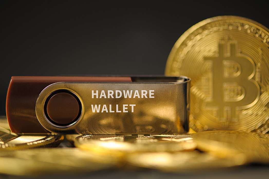 close-up of hardware wallet or digital wallet on bitcoin gold coins in cryptocurrency trading and mining investment concept.