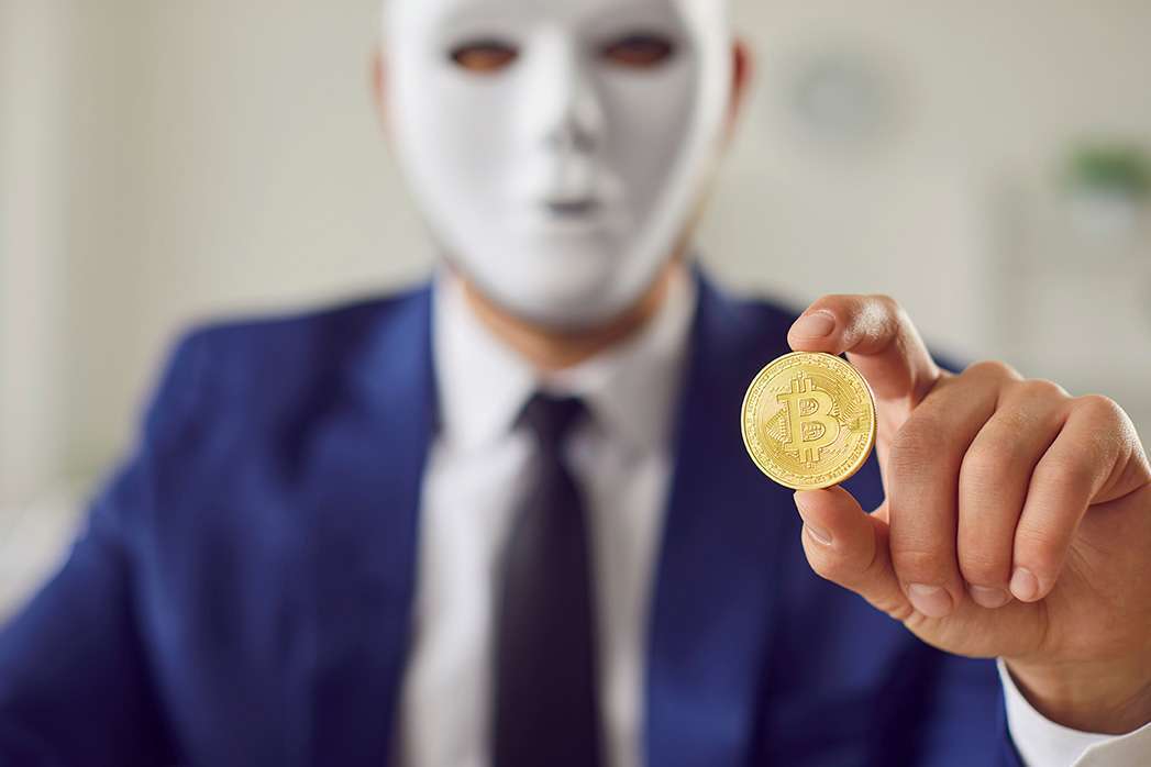 Bitcoin in hand of masked secret man