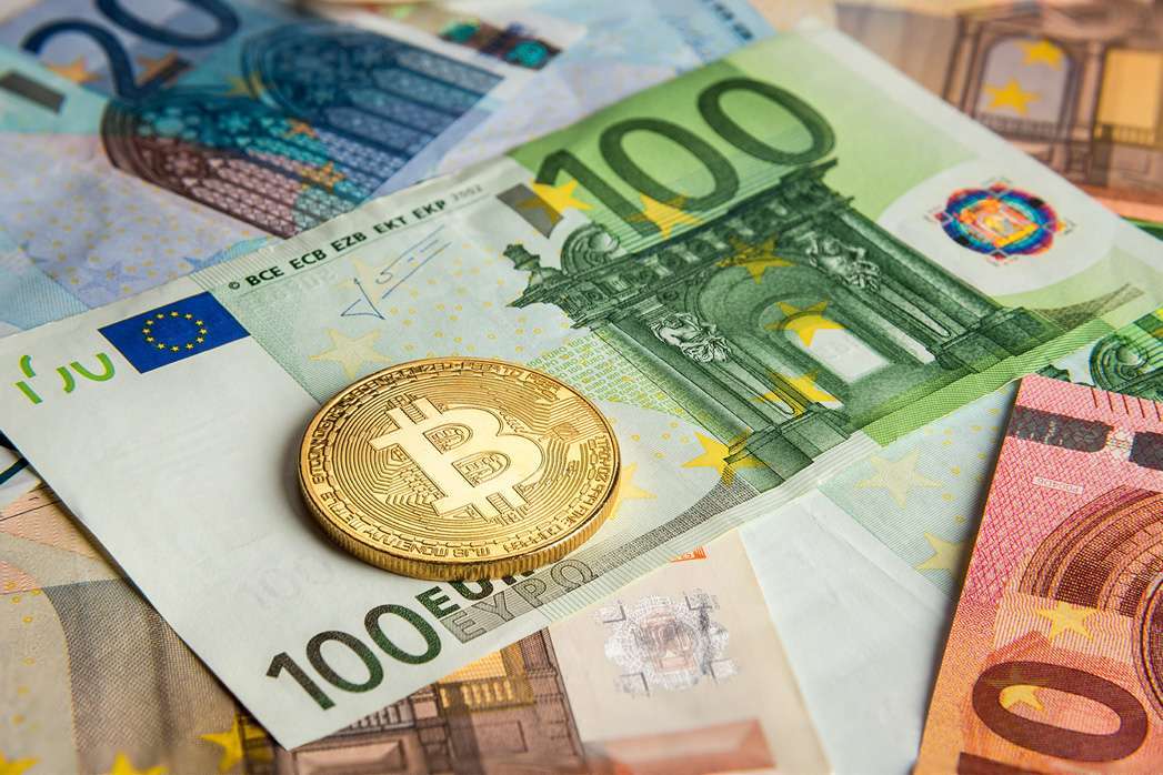 Bitcoin gold coin on euro banknotes.
