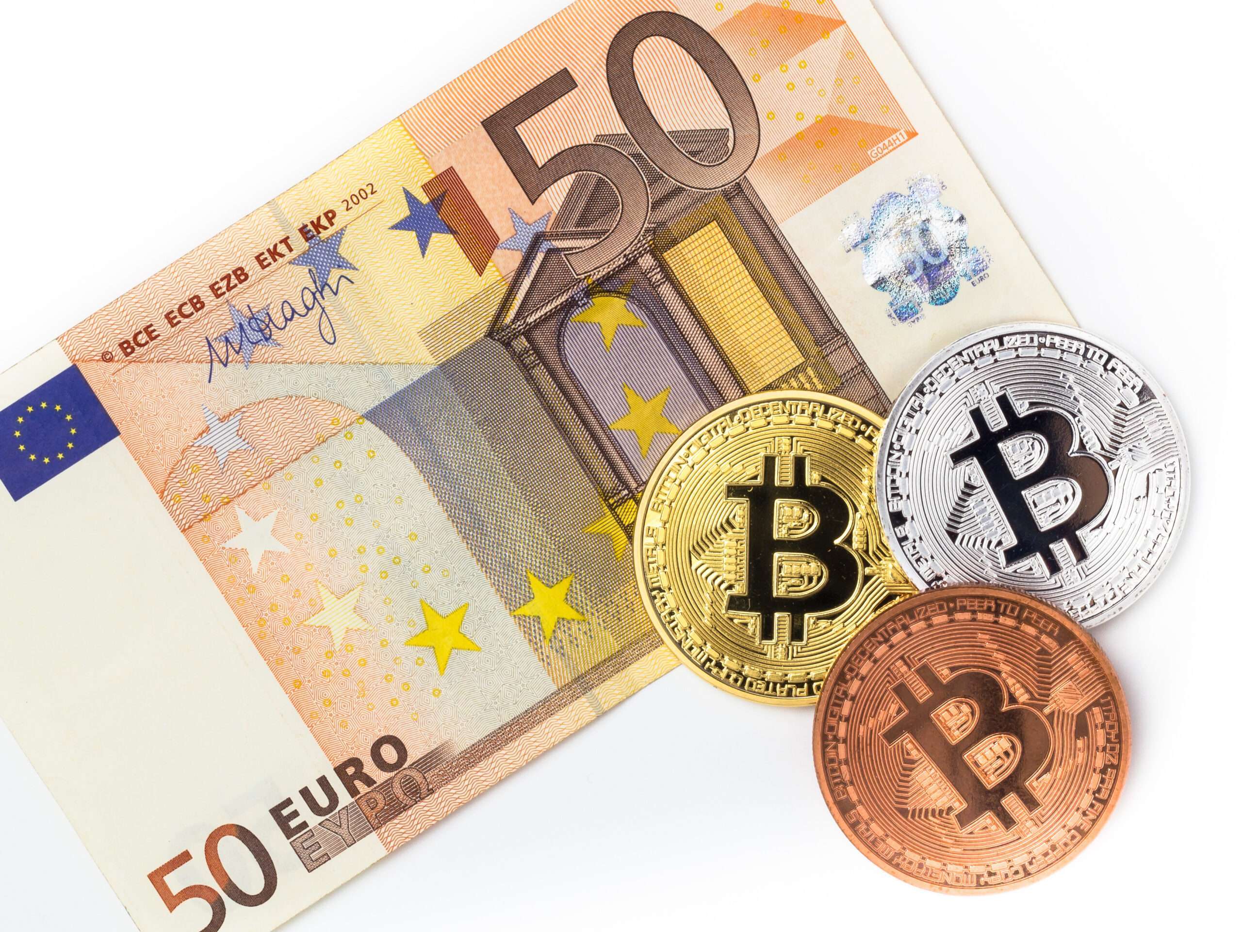 Bitcoins and fifty euro banknote. Financial concept with Bitcoins on fifty euro banknote. Traditional money vs cryptocurrency concept.