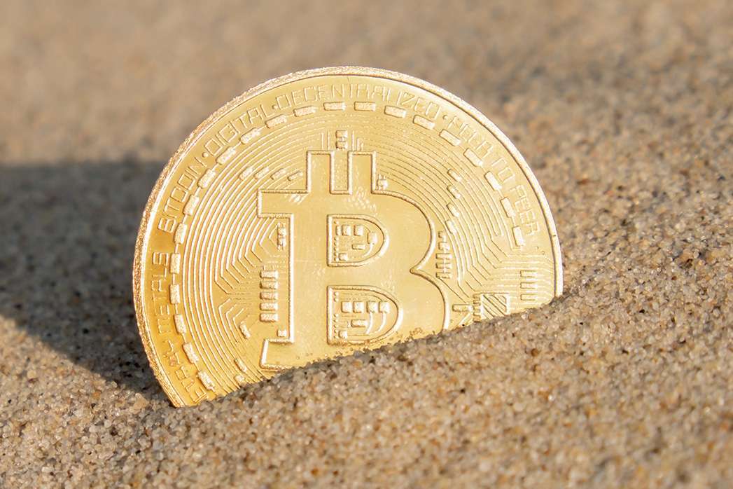 Bitcoin Coin cryptocurrency In Sand On Beach. Freelance, stock exchange BTC sign Concept mining.