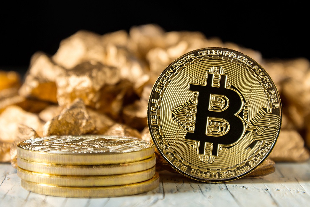 Golden Bitcoin Coin and a mound of gold on a dark background.