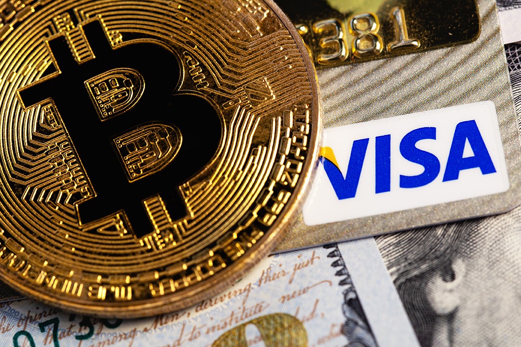 bitcoin cryptocurrency with Visa credit card and dollars, money. Visa - American multinational company providing services of payment operations. Moscow, Russia.