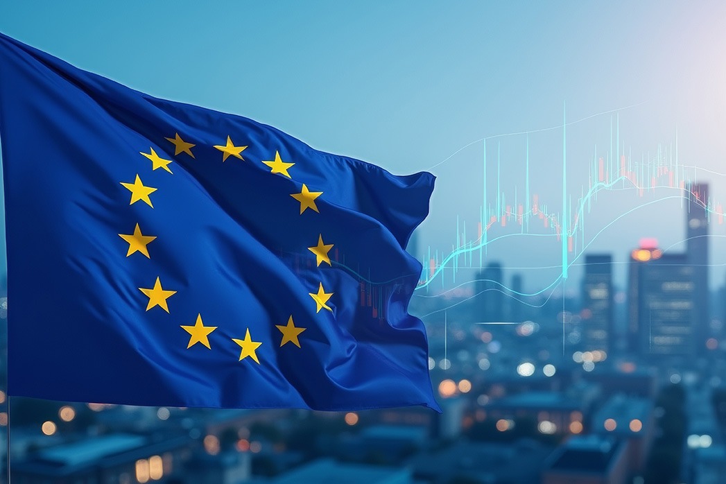 European Union flag waves in the foreground with cityscape and financial graphs, symbolizing economic trends and developments in the EU region.