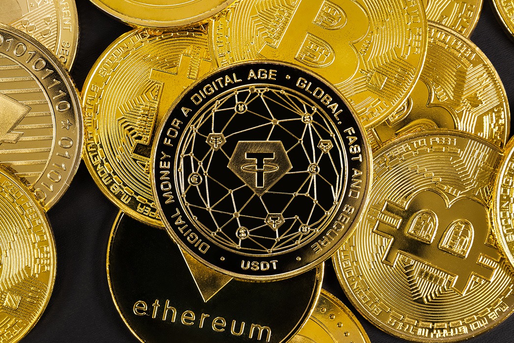Close-up of Tether coin on top of various cryptocurrencies.