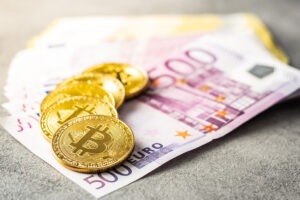 Euro banknotes and bitcoins. Coins of cryptocurrency.