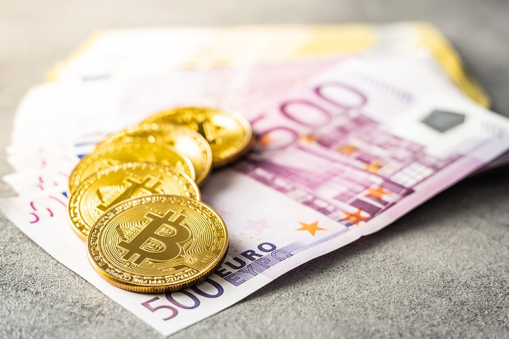 Euro banknotes and bitcoins. Coins of cryptocurrency.