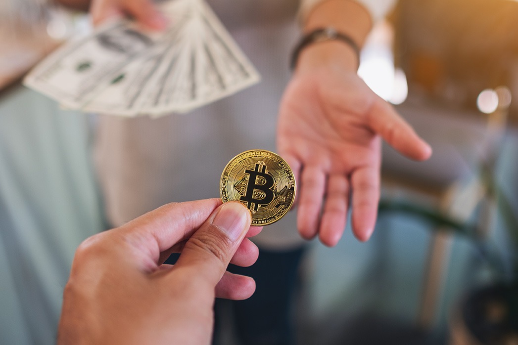 Closeup image of people holding and exchange or convert bitcoins to dollars banknotes.