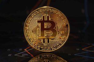 Gold bitcoin standing on financial graphs for cryptocurrency prices.