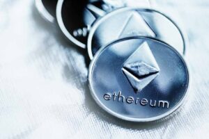 Close-up of Ethereum coin cryptocurrency over a silver background.