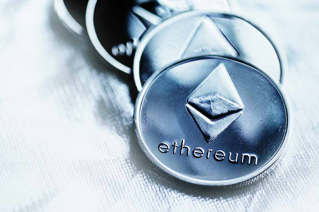 Close-up of Ethereum coin cryptocurrency over a silver background.