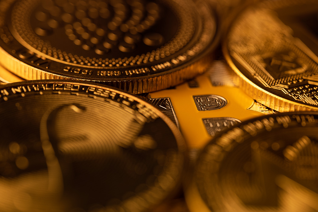 top view macro closeup of crypto bitcoin silver coin on top of other cryptocurrency coins.