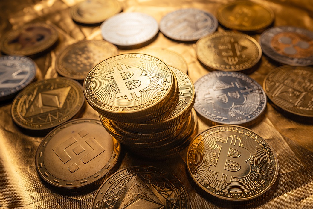 Cryptocurrency coin and bitcoin on a golden background.
