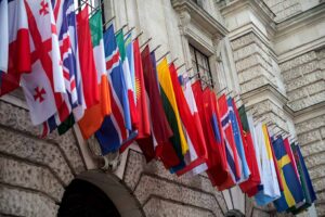 An assortment of various countries' flags is seen on the balcony of a building.