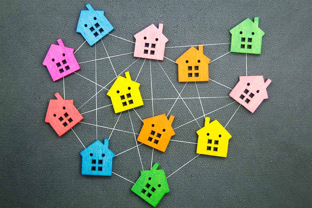 Colourful Houses Connected by a Network on a Grey Background.