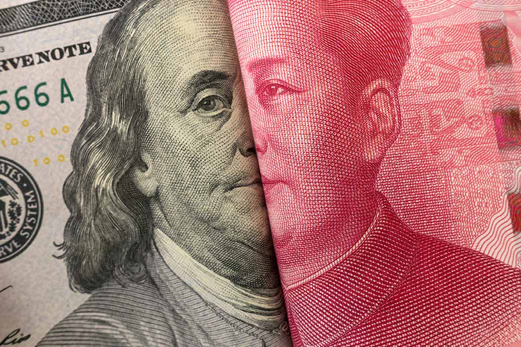 American dollar and Yuan banknote with USA and China flags. It's a symbol of the tariff trade war crisis between the world's largest economies.
