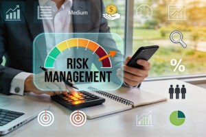 Executive evaluating risk management dashboard with calculator and mobile device, medium risk level indicator, financial planning tools, investment strategy icons, team.
