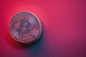 Close-up of Bitcoin Currency on Red Background.